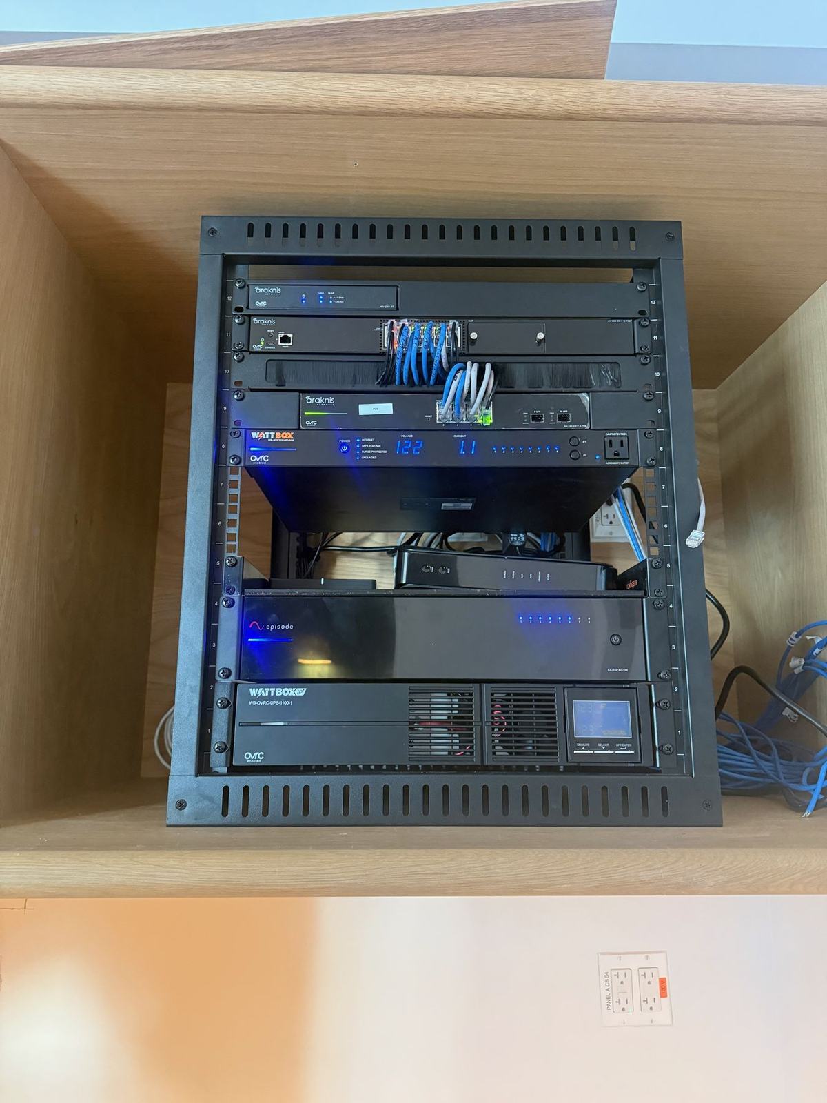Equipment rack built into oak cabinetry at a Bridgehampton café