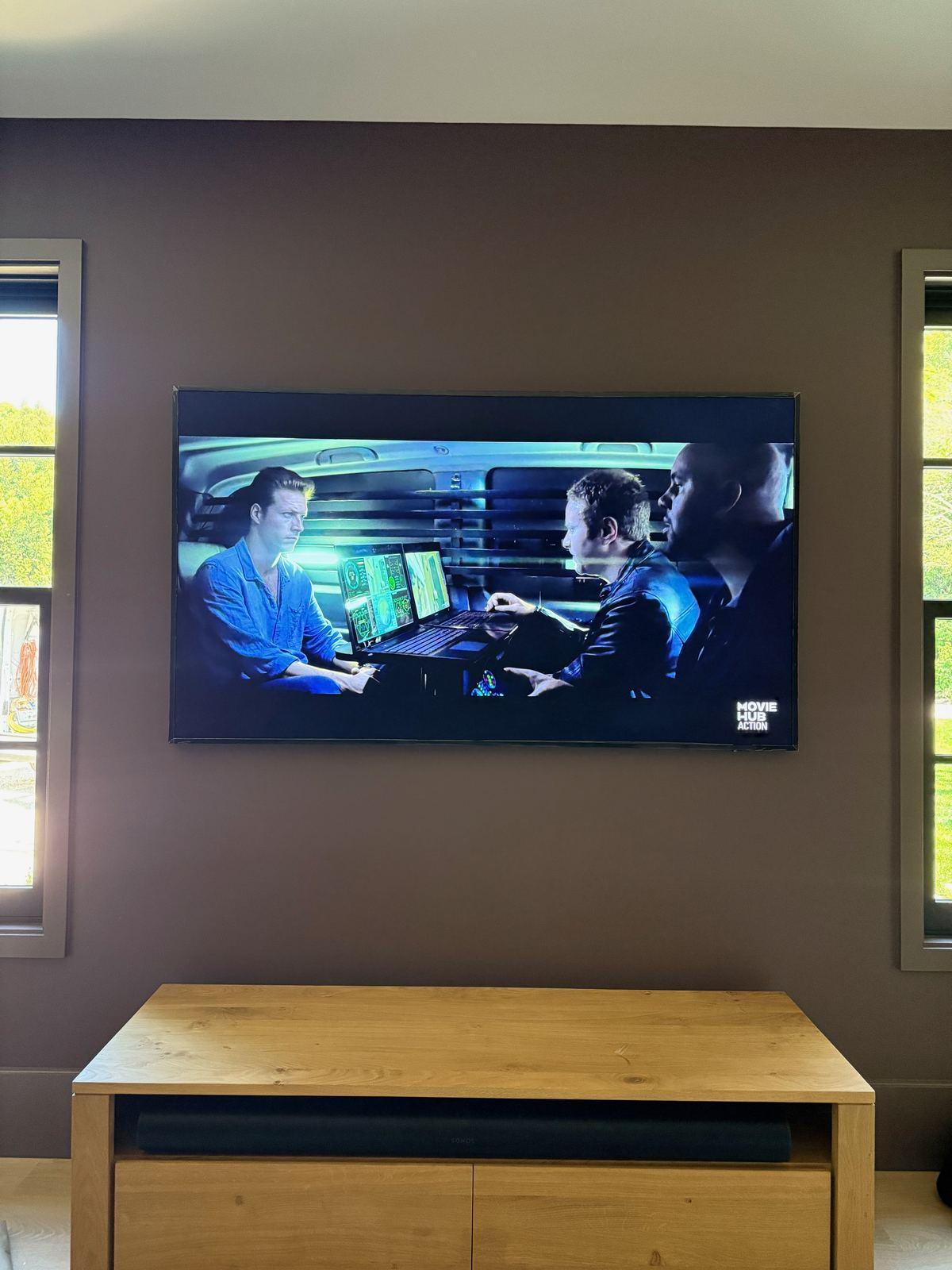 Wall-mounted TV above an oak media console with soundbar in a Hamptons living room, installed by HamptonTek