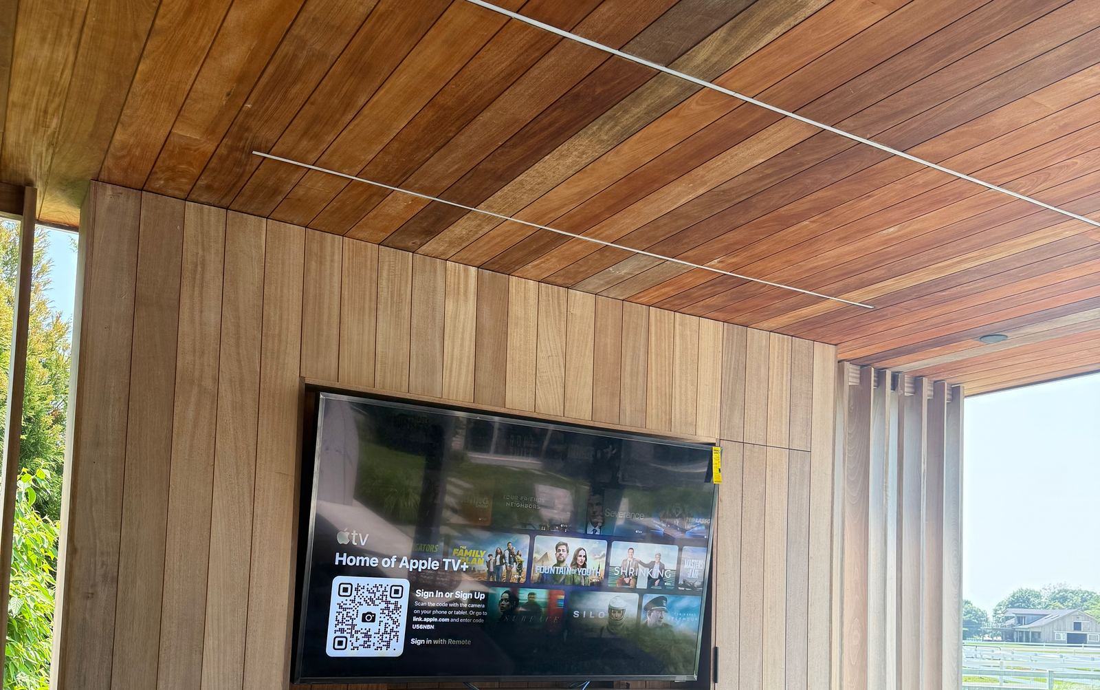 Outdoor TV set into a wood-paneled pool house in the Hamptons